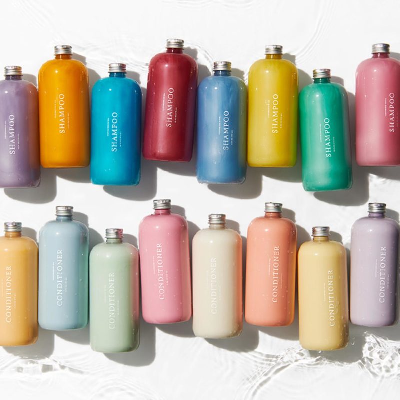 ShampooConditioner_Lineup Glass bottles with colourful shampoo and conditioner