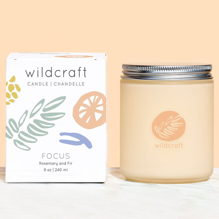 improve-mood-luxury-home-scents-wildcraft-focus-candle A Wildcraft Focus Candle with glass jar and tin lid, beside the box it comes in.