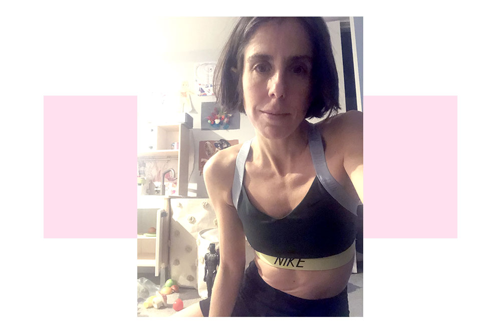 Miriam Zittell takes a selfie before a workout in a room filled with toys