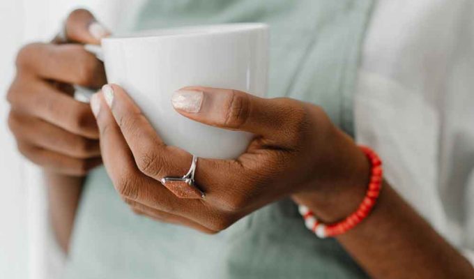 A woman holding a cup of coffee with collagen