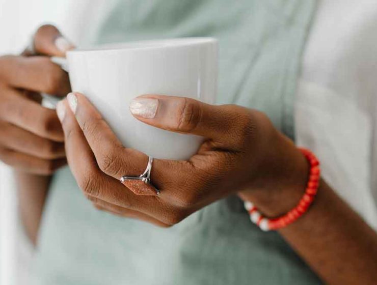A woman holding a cup of coffee with collagen