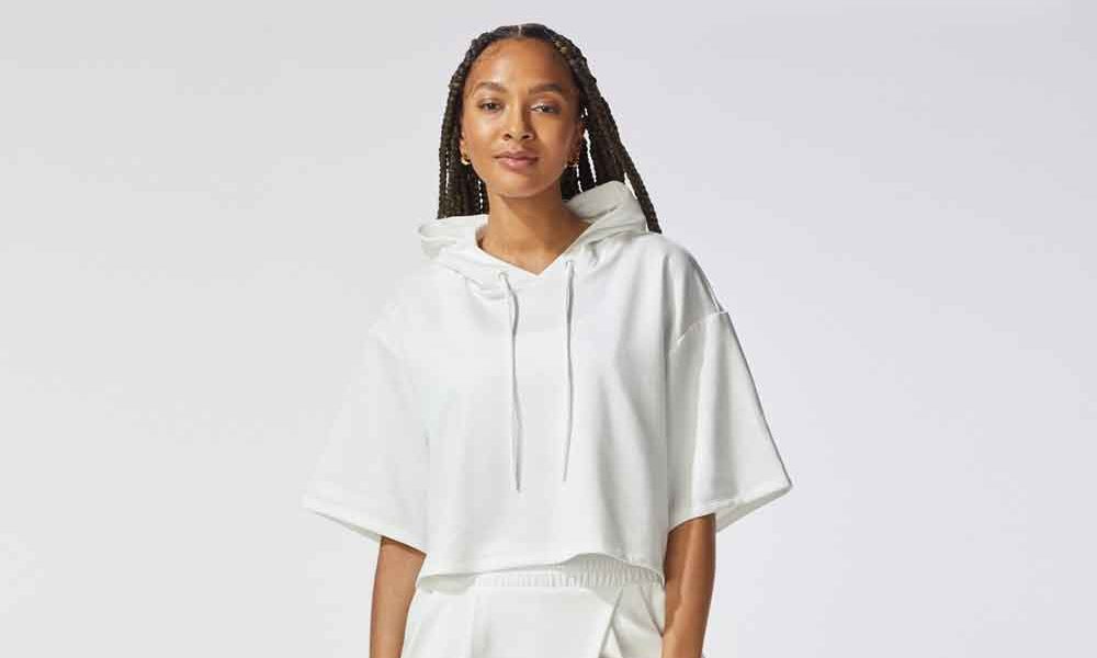 A woman in an oversized, cropped sleeve michi hoodie. So cute!