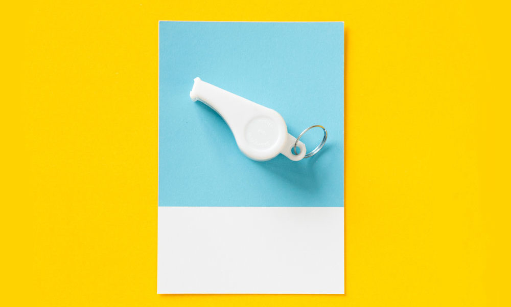 A whistle sits on a card, symbolizing the role of a life coach