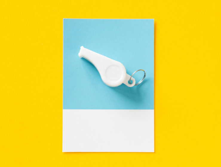 A whistle sits on a card, symbolizing the role of a life coach