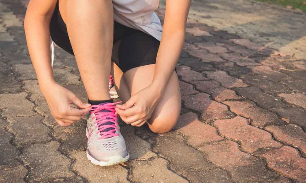 A woman lacing up her shoes