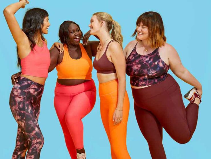 Four women of various sizes wearing sports bras and leggings that fit comfortably