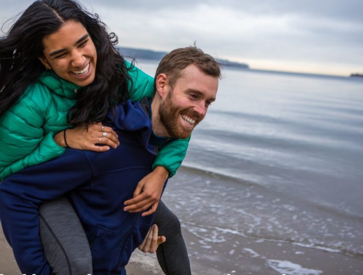 man-piggybacking-woman-by-ocean