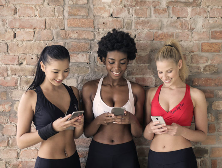 Three women at the studio, checking their data on their phones