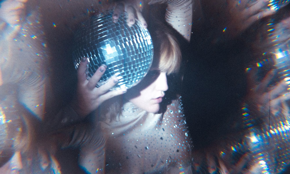 A woman holding a disco ball, which is kind the perfect compromise for a new year's story about trend predictions, right?