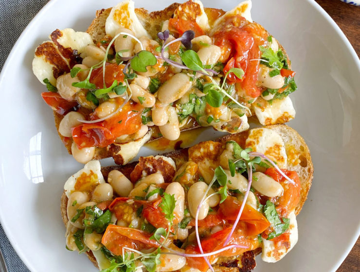 Two pieces of toast topped with cheese, beans and peppers, loaded with texture in every bite.