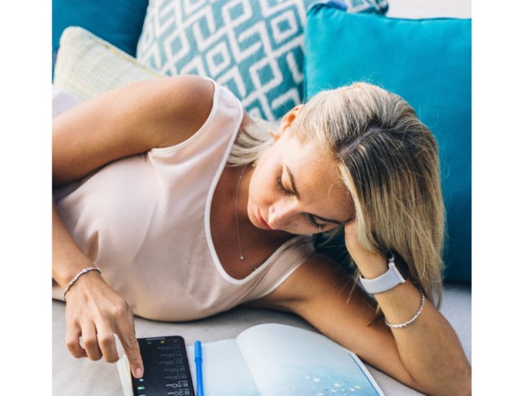woman-lying-on-couch-scrolling-phone
