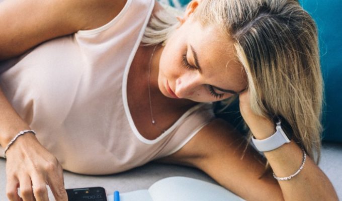 woman-lying-on-couch-scrolling-phone