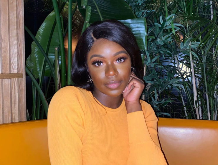 Joelle Kabisoso has her hand on her cheek as she smiles confidently