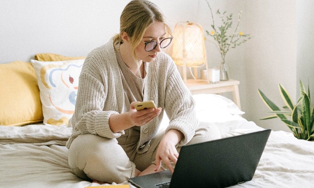 woman-sitting-on-bed-with-laptop