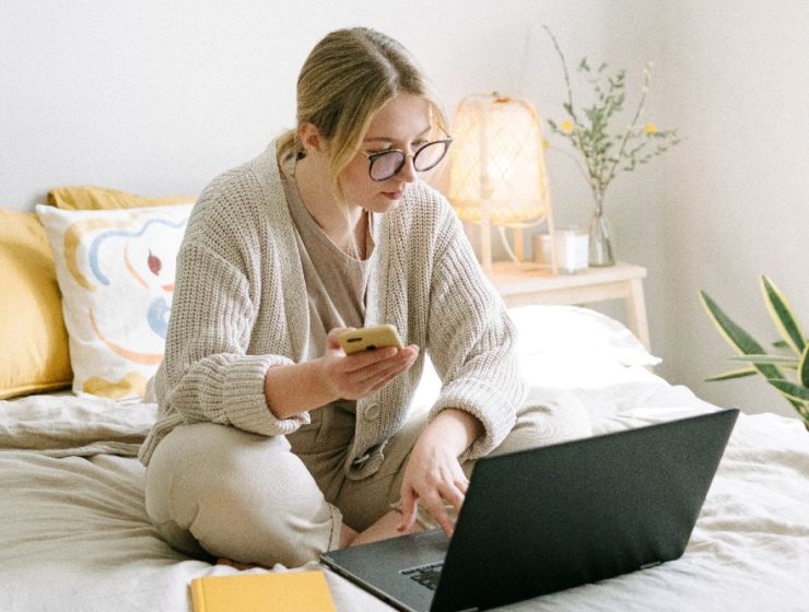 woman-sitting-on-bed-with-laptop