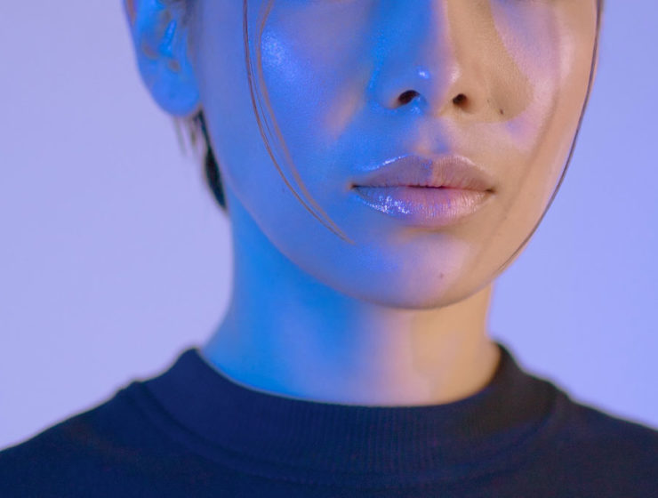 A woman with shiny cheeks and lips, looking well hydrated and glossy.