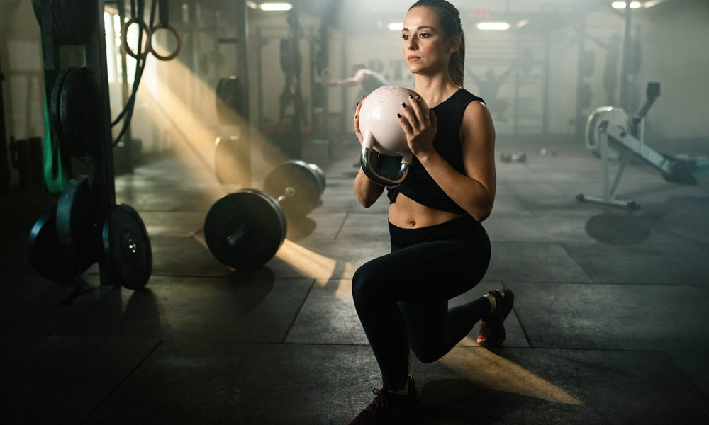 A woman holds a kettlebell as she completes a lunge, as part of the 30 lunges for 30 days challenge