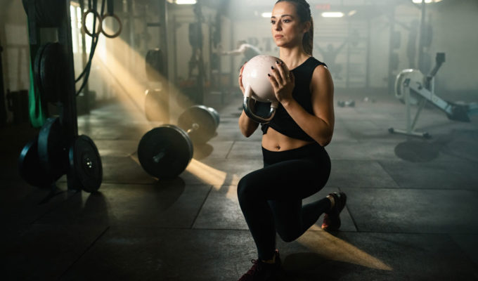 A woman holds a kettlebell as she completes a lunge, as part of the 30 lunges for 30 days challenge