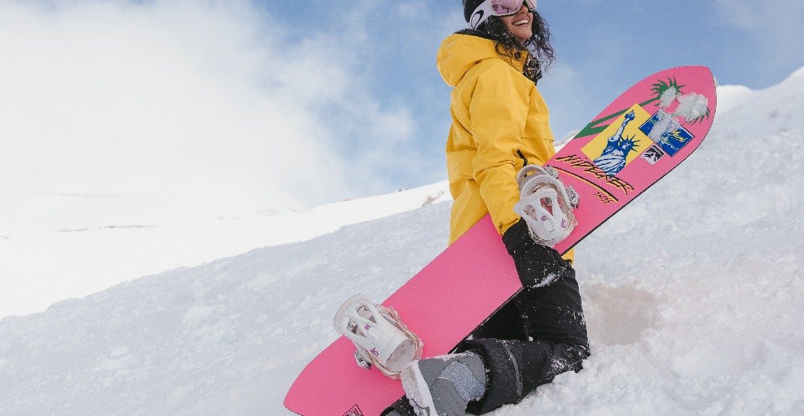 woman with snowboard on mountain