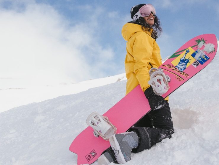 woman with snowboard on mountain