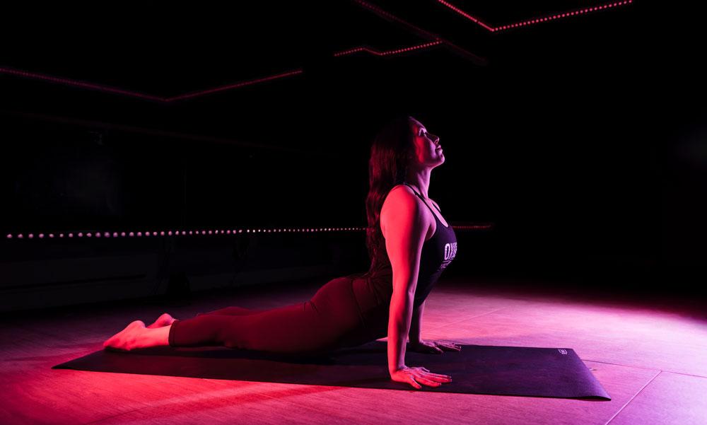 A woman doing upward dog in an infrared-heated room at Oxygen Yoga & Fitness