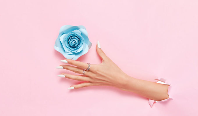 To symbolize improving mood with home fragrance, a hand reaches through wallpaper to grab a flower