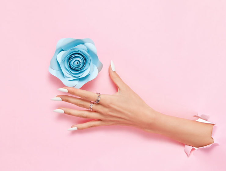 To symbolize improving mood with home fragrance, a hand reaches through wallpaper to grab a flower