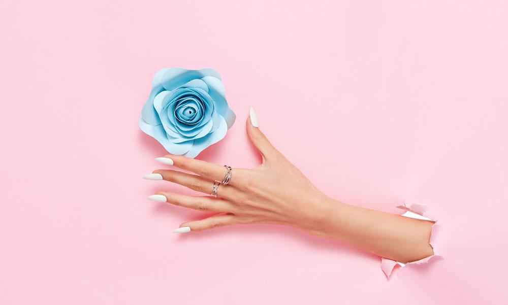 To symbolize improving mood with home fragrance, a hand reaches through wallpaper to grab a flower