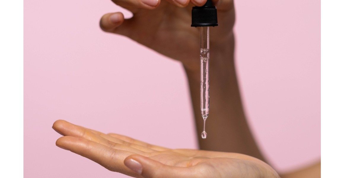 woman holding serum dropper in hands