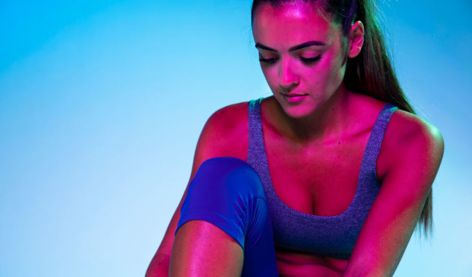 A woman tying up her monochromatic shoes.