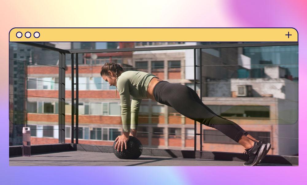 A woman doing a medicine ball plank with the NYC skyscape in the background