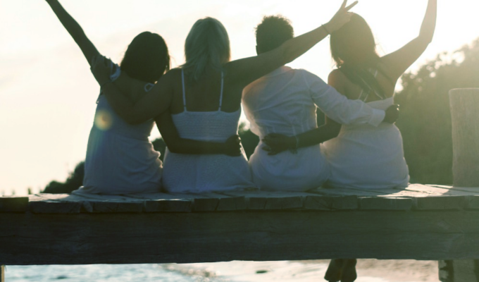 Four women on a dock, having the best long weekend ever, because they packed a fun emergency kit